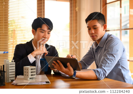 Architects men looking at digital tablet while working with architectural model model at office 112284240