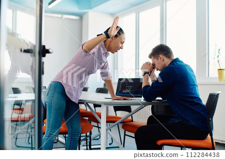 A furious business director of a startup office berating her employee for business mistakes and errors 112284438