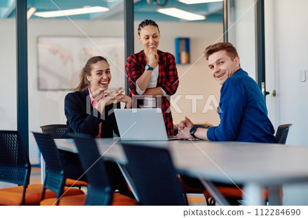 A team of successful programmers sits in a startup office, strategizing new business projects and solving existing challenges, showcasing innovation and collaboration in the tech industry 112284690