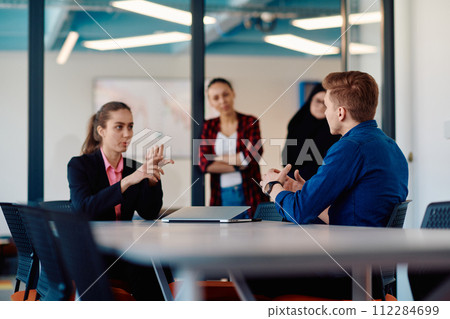 A team of successful programmers sits in a startup office, strategizing new business projects and solving existing challenges, showcasing innovation and collaboration in the tech industry 112284699