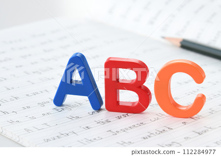 Alphabet blocks placed on English notebook 112284977
