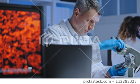 Scientist adjusting microscope to examine blood sample, diagnostics and treatment Scientist adjusting microscope to examine blood sample, diagnostics and treatment 112285325
