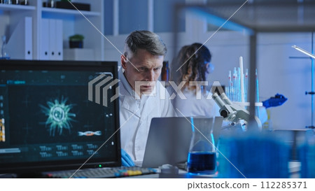 Biological laboratory scientist studying experiment results on laptop, research Biological laboratory scientist studying experiment results on laptop, research 112285371