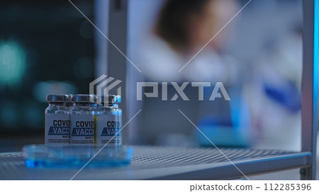Close-up of Covid-19 vaccine bottles standing on shelf, disease prevention, vaccination 112285396