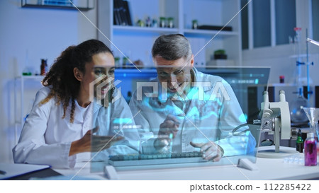 Two scientists satisfied with experiment results, looking at holographic screen 112285422