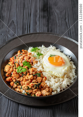 basil chicken stir fry with rice and fried egg 112286080
