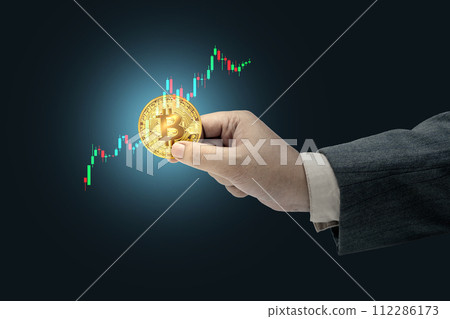 Business hand holding bitcoin with financial chart 112286173