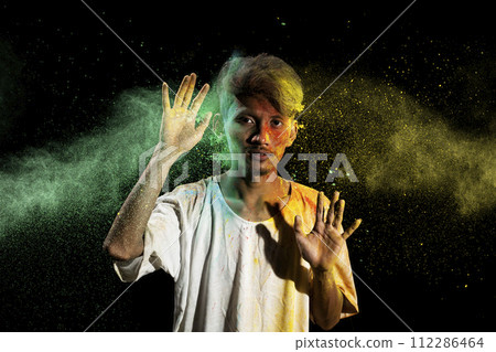 Portrait of a man celebrating Holi with colorful Holi powder Portrait of a man celebrating Holi with colorful Holi powder 112286464