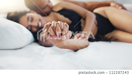 Couple, holding hands and wake up in bed with happy, love and support together in a hotel. Bedroom, trust and bonding with marriage and commitment of people with a smile from relax and calm morning Couple, holding hands and wake up in bed with happy, love and support together in a hotel. Bedroom, trust and bonding with marriage and commitment of people with a smile from relax and calm morning 112287243