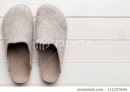 Warm winter women woolen slippers on the floor. Copy space for text Warm winter women woolen slippers on the floor. Copy space for text 112287646