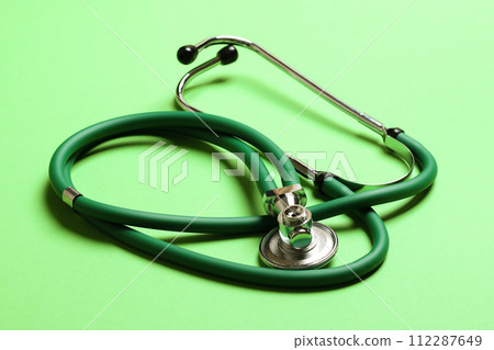 Top view of green medical stethoscope on colorful background with copy space. Medicine equipment concept Top view of green medical stethoscope on colorful background with copy space. Medicine equipment concept 112287649