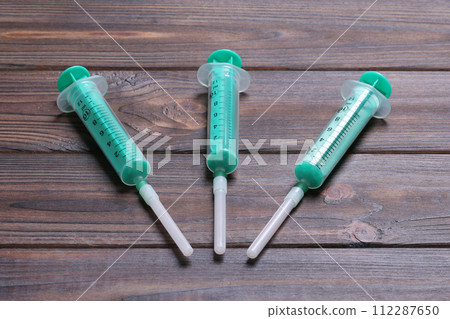 Top view of syringes on wooden background with copy space. Medical equipment for injection concept 112287650