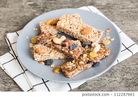 Various granola bars on table background. Cereal granola bars. Superfood breakfast bars with oats, nuts and berries, close up. Superfood concept 112287661