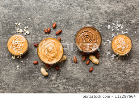 Glass jar with peanut butter on table background, top view space for text and close up 112287664