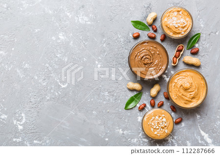 Glass jar with peanut butter on table background, top view space for text and close up 112287666