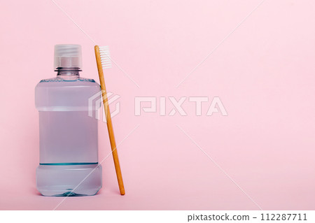 Mouthwash and other oral hygiene products on colored table top view with copy space. Flat lay. Dental hygiene. Oral care products and space for text on light background. concept 112287711
