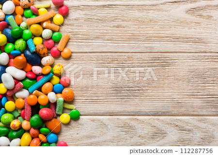 Mixed collection of colorful candy, on colored background. Flat lay, top view. frame of colorful chocolate coated candy 112287756