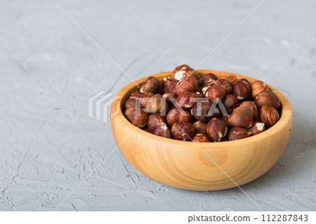 Wooden bowl full of hazelnuts on table background. Healthy eating concept. Super foods Wooden bowl full of hazelnuts on table background. Healthy eating concept. Super foods 112287843
