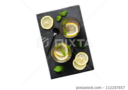 Healthy breakfast or morning with chia seeds lemon and mint on table background, vegetarian food, diet and health concept. Chia pudding with lemon and mint Healthy breakfast or morning with chia seeds lemon and mint on table background, vegetarian food, diet and health concept. Chia pudding with lemon and mint 112287857