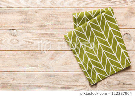top view with green kitchen napkin isolated on table background. Folded cloth for mockup with copy space, Flat lay. Minimal style 112287904