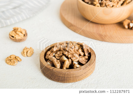 Fresh healthy walnuts in bowl on colored table background. Top view Healthy eating bertholletia concept. Super foods Fresh healthy walnuts in bowl on colored table background. Top view Healthy eating bertholletia concept. Super foods 112287971