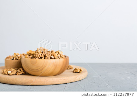 Fresh healthy walnuts in bowl on colored table background. Top view Healthy eating bertholletia concept. Super foods Fresh healthy walnuts in bowl on colored table background. Top view Healthy eating bertholletia concept. Super foods 112287977