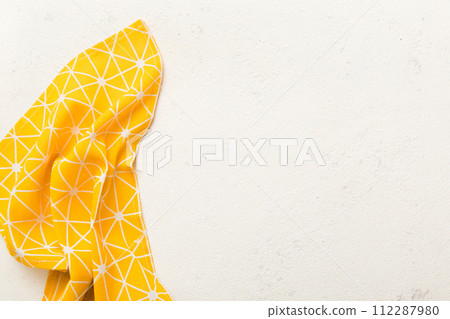 top view with yellow empty kitchen napkin isolated on table background. Folded cloth for mockup with copy space, Flat lay. Minimal style top view with yellow empty kitchen napkin isolated on table background. Folded cloth for mockup with copy space, Flat lay. Minimal style 112287980