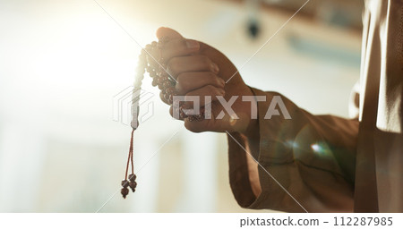 Muslim, prayer beads and hand of man in mosque with tasbih for spiritual, meditation and mindfulness in religion. Counting, dhikr and person praying in Islam, faith with hope in God in the morning 112287985