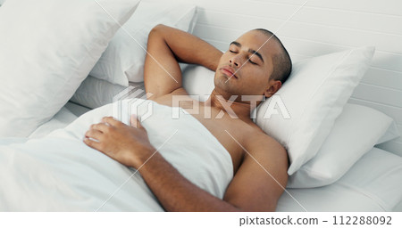 Man, eyes closed and sleeping in bed at home, peace and dreaming or relax on sunday morning. Male person, comfortable and blanket for resting, lazy and house nap on soft bedding and calm on weekend 112288092