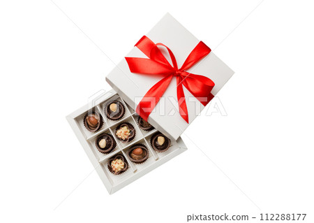 Chocolate candy in a box with a colored bow. Gift box with Chocolates isolated on white top view 112288177