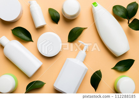 Organic cosmetic products with green leaves on color background. Flat lay Organic cosmetic products with green leaves on color background. Flat lay 112288185