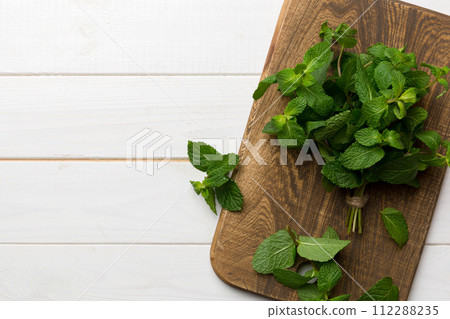 Fresh mint on Cutting board table, top view. Flat lay Space for text Fresh mint on Cutting board table, top view. Flat lay Space for text 112288235