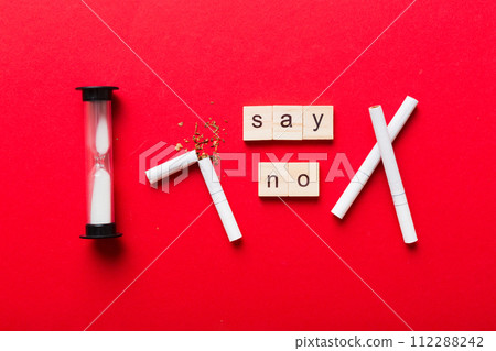 Cigarette And Wooden Blocks, Broken cigarette on table background with hourglass, No Tobacco Day with hourglass, clock health concept. time to quit smoking Cigarette And Wooden Blocks, Broken cigarette on table background with hourglass, No Tobacco Day with hourglass, clock health concept. time to quit smoking 112288242