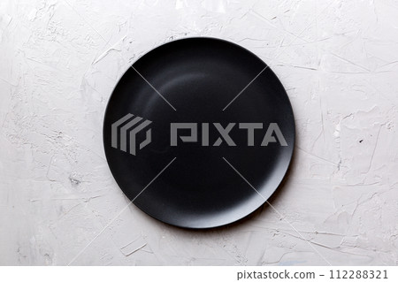 Top view of black plate on cement background. Empty space for your design 112288321
