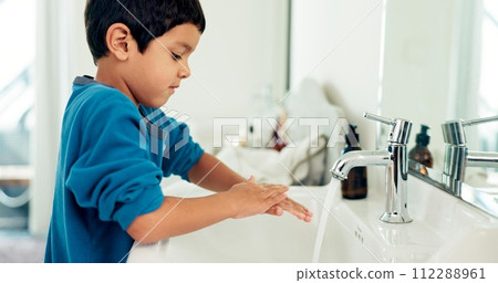 Young boy, washing hands and hygiene for health, sustainability and water at routine at home. Male child, bathroom and clean with soap, foam and sink in healthy with hand washing and disinfection 112288961