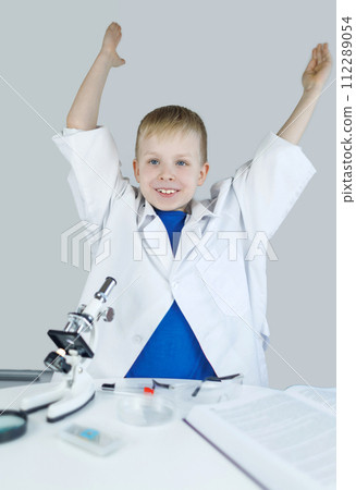 Child chemist. Teacher shows a visual experiment. A science mentor teaches an experimental approach. Microscope, petri dish, pipettes, books. Practical work in chemistry or physics. Laboratory work Child chemist. Teacher shows a visual experiment. A science mentor teaches an experimental approach. Microscope, petri dish, pipettes, books. Practical work in chemistry or physics. Laboratory work 112289054