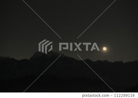 當夜晚的星星閃爍時，地照 2.2 彎月落在南阿爾卑斯山的凱駒嶽山脈上空。 112289116