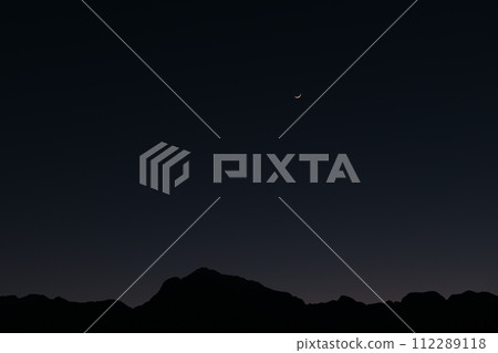 A 2.2-year-old crescent moon over Mt. Kaikomagatake in the Southern Alps during blue hour 112289118