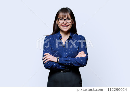 Portrait of smiling business mature woman with crossed arms on white background 112290024