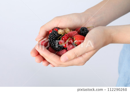 Ripe berries, in hands, close-up, on a light background. Ripe berries, in hands, close-up, on a light background. 112290268
