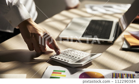 Desk with calculators for calculating, managing and analyzing economic profits and losses. 112290384