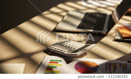 Desk with calculators for calculating, managing and analyzing economic profits and losses. Desk with calculators for calculating, managing and analyzing economic profits and losses. 112290385