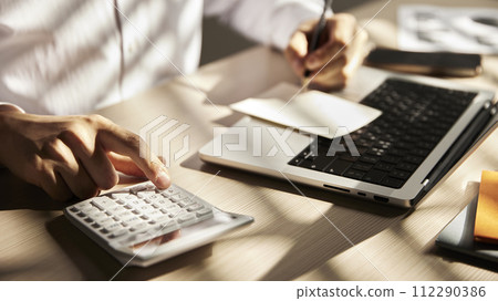 Desk with calculators for calculating, managing and analyzing economic profits and losses. Desk with calculators for calculating, managing and analyzing economic profits and losses. 112290386