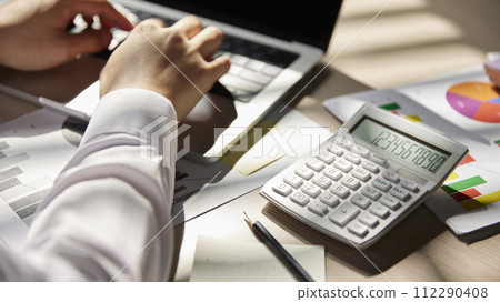Desk with calculators for calculating, managing and analyzing economic profits and losses. 112290408