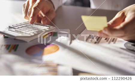 Desk with calculators for calculating, managing and analyzing economic profits and losses. Desk with calculators for calculating, managing and analyzing economic profits and losses. 112290426