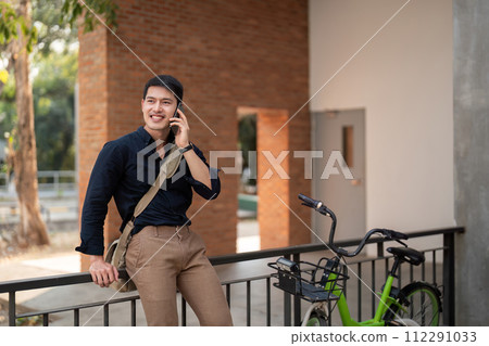 Eco friendly, Happy lifestyle asian young businessman ride bicycle go to office work at city street with bicycle in morning Eco friendly, Happy lifestyle asian young businessman ride bicycle go to office work at city street with bicycle in morning 112291033
