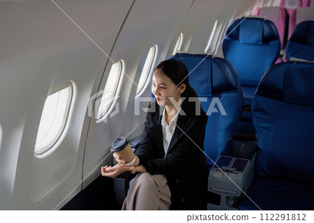Successful asian businesswoman or female entrepreneur in a plane sits in a business class seat 112291812