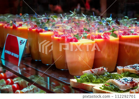 Gazpacho, traditional Spanish cold soup, served as a drink at a food market Gazpacho, traditional Spanish cold soup, served as a drink at a food market 112292701