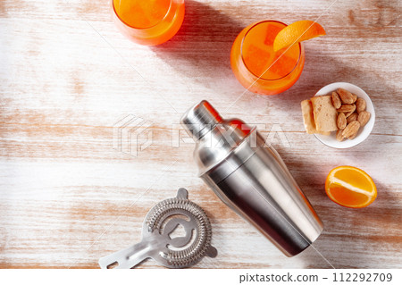 Orange cocktails and a shaker, overhead flat lay shot on a wooden background 112292709