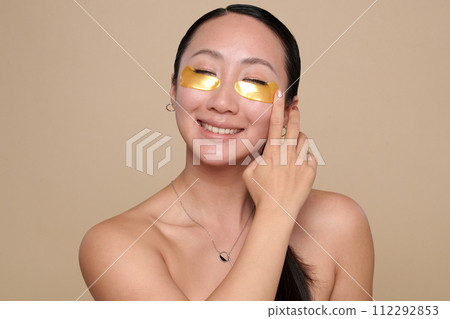 Portrait of happy excited young woman applying hydrogel patches Portrait of happy excited young woman applying hydrogel patches 112292853